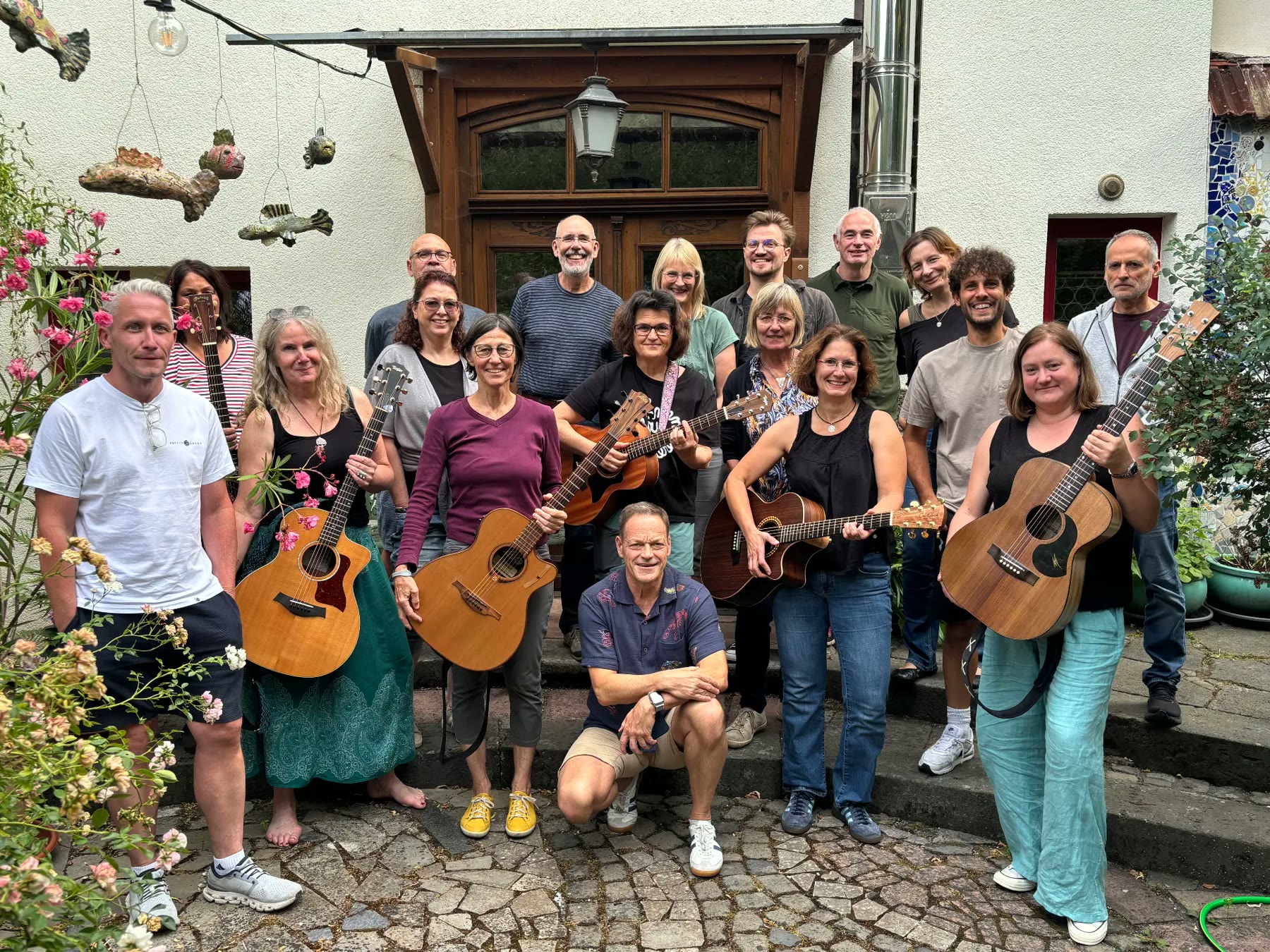 Gruppenfoto aller Teilnehmenden mit Gitarren im Innenhof