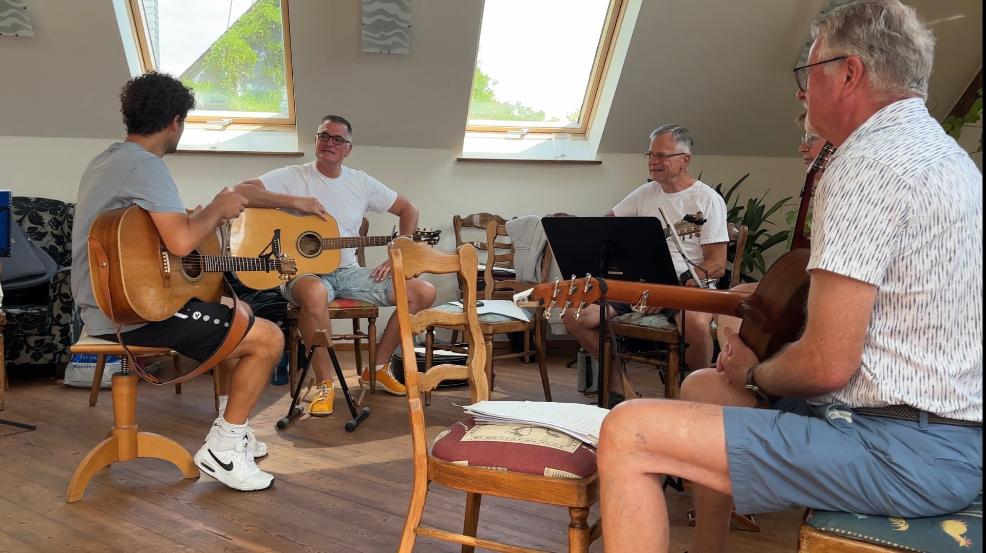 Teilnehmer und Gitarrenlehrer im Gespräch mit Gitarren